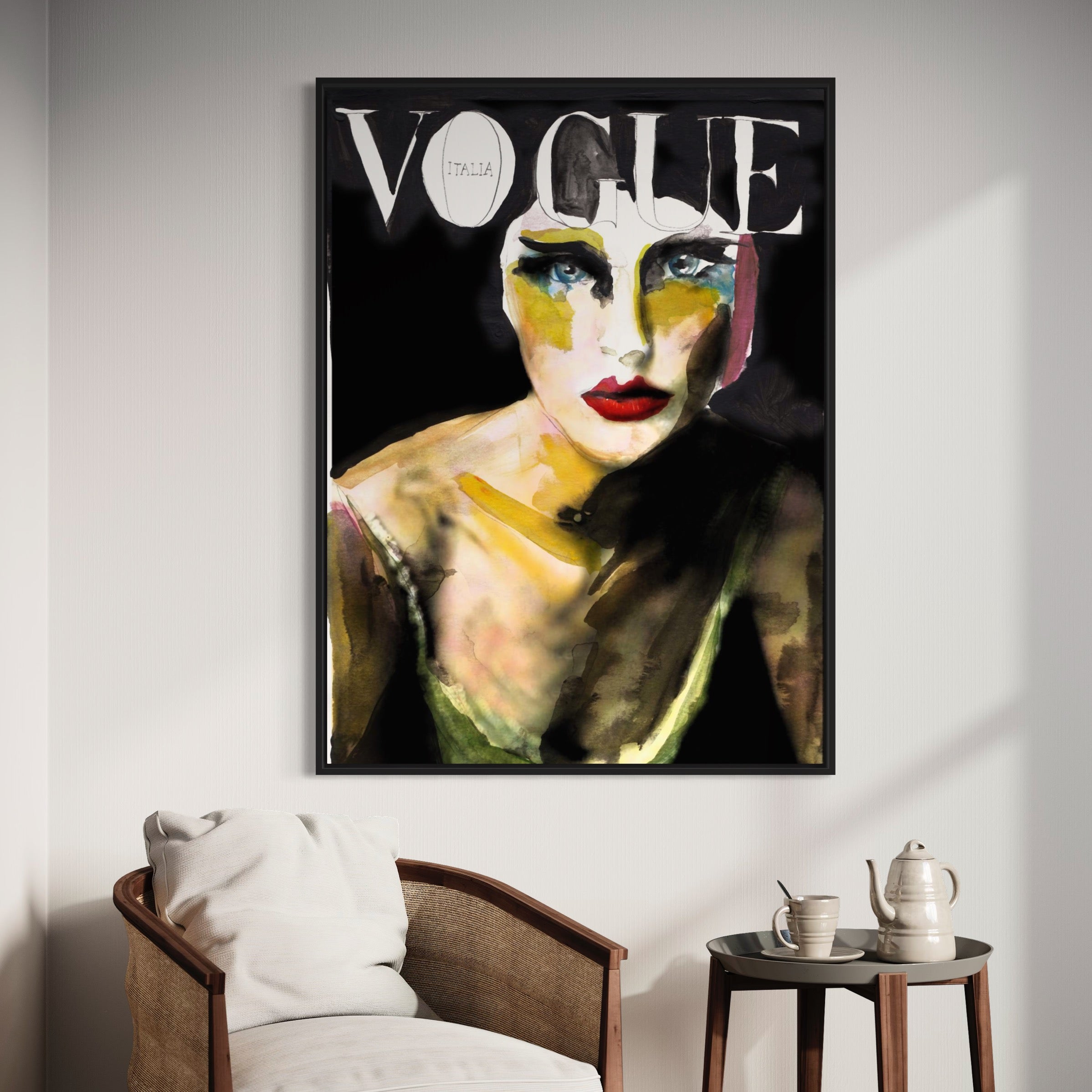A framed 8 Vogue Italia cover with vibrant hand-painted wall art of a womans face adds flair to the space. A chair with a white cushion sits by a wooden table featuring a teapot and cup, offering an ambiance of high fashion and contemporary art.