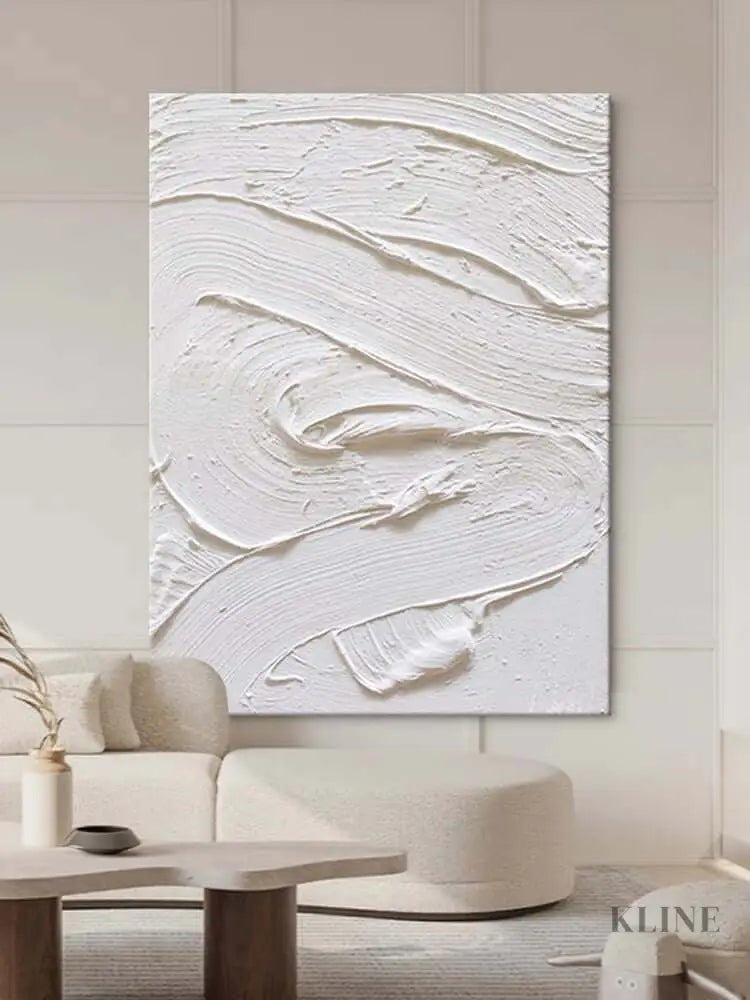 White textured oil painting abstract artwork hung in a modern living room, showcasing minimalist design and intricate surface detail.