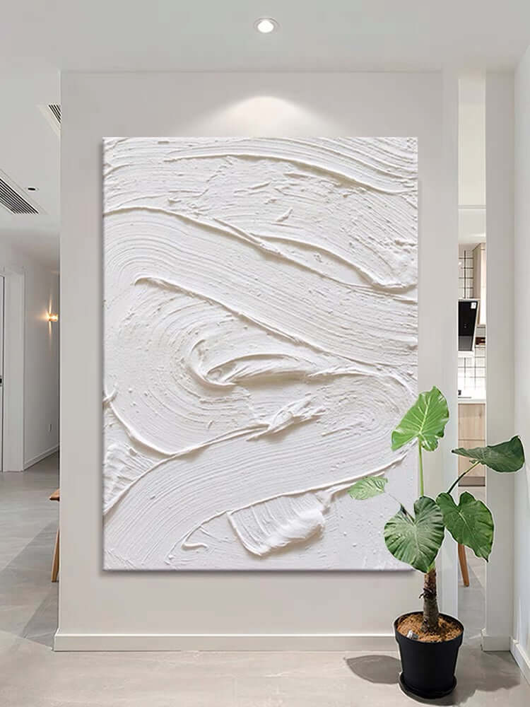 White textured oil painting on a wall, showcasing minimalism and abstract design in an elegant interior.