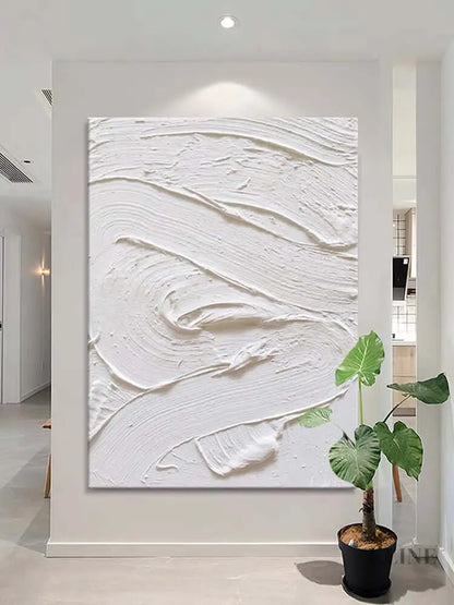 White textured oil painting on a wall, showcasing minimalism and abstract design in an elegant interior.