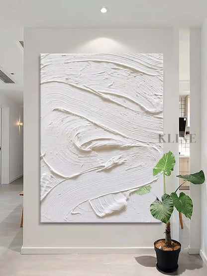 White textured oil painting on a wall, showcasing minimalism and abstract design in an elegant interior.