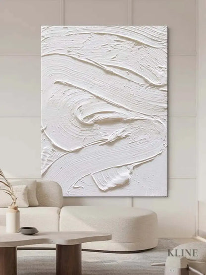 White textured oil painting abstract artwork hung in a modern living room, showcasing minimalist design and intricate surface detail.